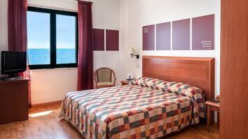 Driepersoonskamer, uitzicht op zee | Een minibar, een kluis op de kamer, een bureau, geluiddichte muren