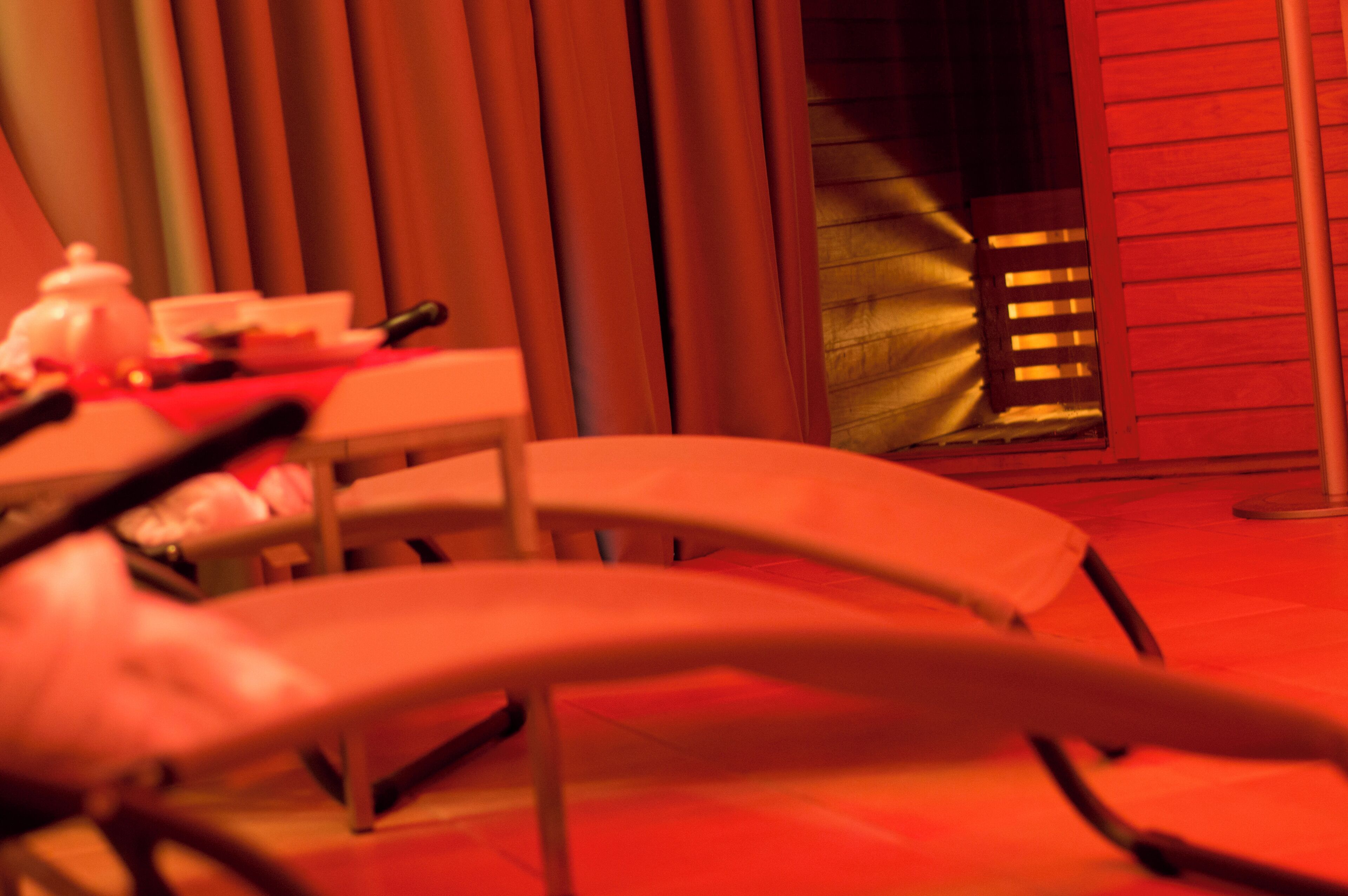 A dining area with a table and chairs, a window with blinds, and a door leading to another room.