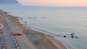 Een privéstrand, ligstoelen aan het strand, parasols