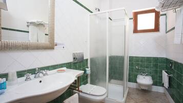 Une salle de bain avec un lavabo, des toilettes et une douche.