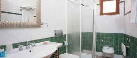 A bathroom with a sink, toilet, and shower.