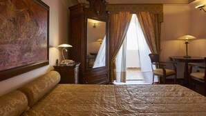 A hotel room with a bed, a desk, a chair, a lamp, and a large mirror. - Hotel Tritone (Lipari)