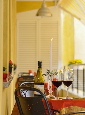 A table set with a bottle of wine, two wine glasses, a lit candle, and a chair. - Bed & Breakfast Ai Cipressi (Lucca)