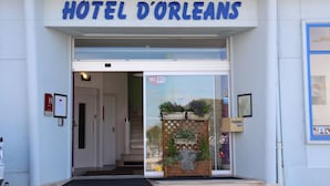 The entrance to Hotel D'Orleans with a clear sign above the door, a Wi-Fi symbol, and a small outdoor display of plants. - Hotel d Orléans (Angouleme)