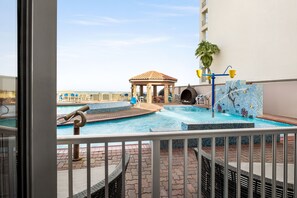 Un área de piscina en la azotea con un pabellón, sillas de descanso y una fuente.