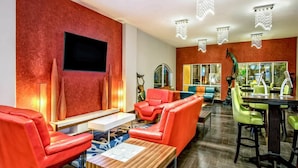 A modern lounge area with leather sofas, a wooden coffee table, and a bar with stools. - La Copa Inn Beach Hotel (South Padre Island)