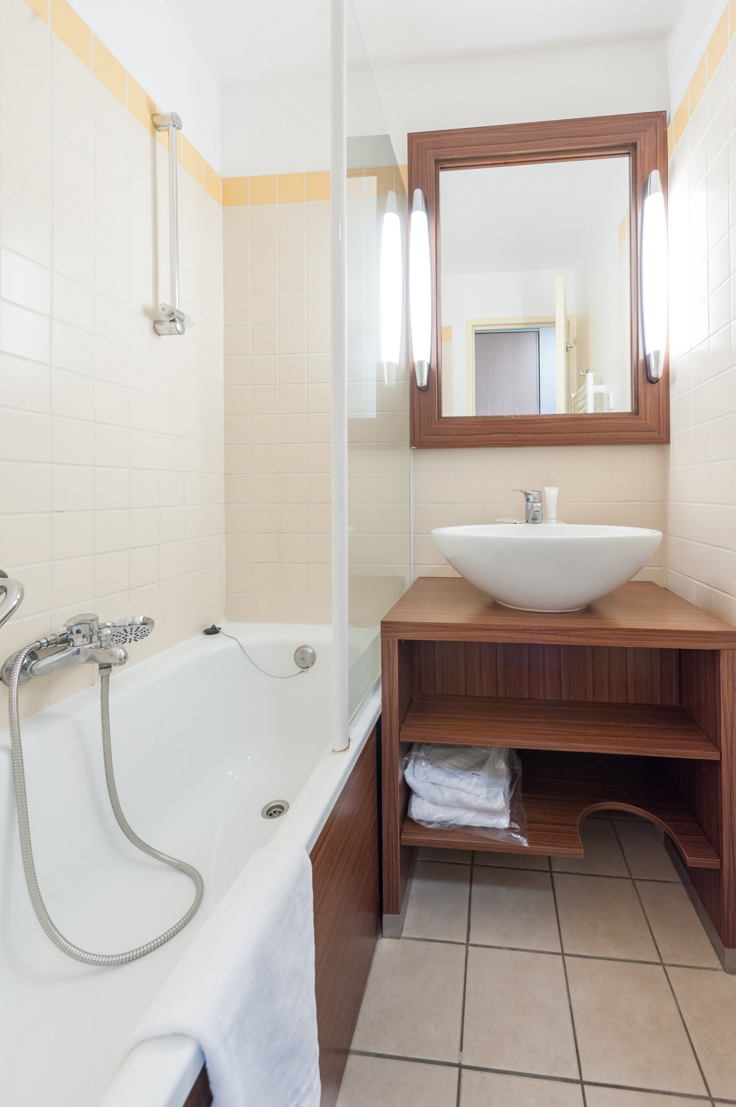 A bathroom with a bathtub, a sink, and a mirror.