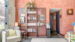Un hall acogedor con una estantería, un sofá, un radiador y una puerta que da a otra habitación.