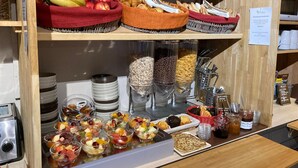 A breakfast buffet with various fruits, pastries, cereals, and beverages. - Logis Hôtel les Aubuns Country Hôtel (Saint-Gilles)