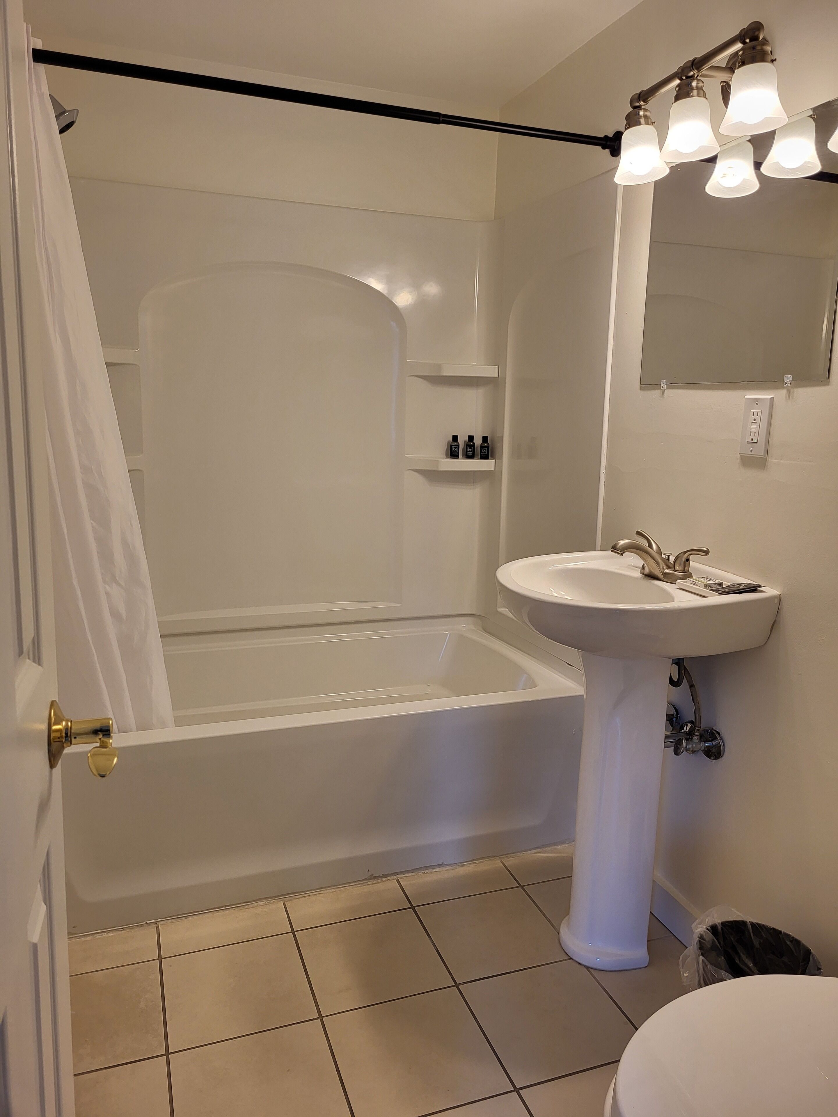 A bathroom with a bathtub, a sink, and a mirror.