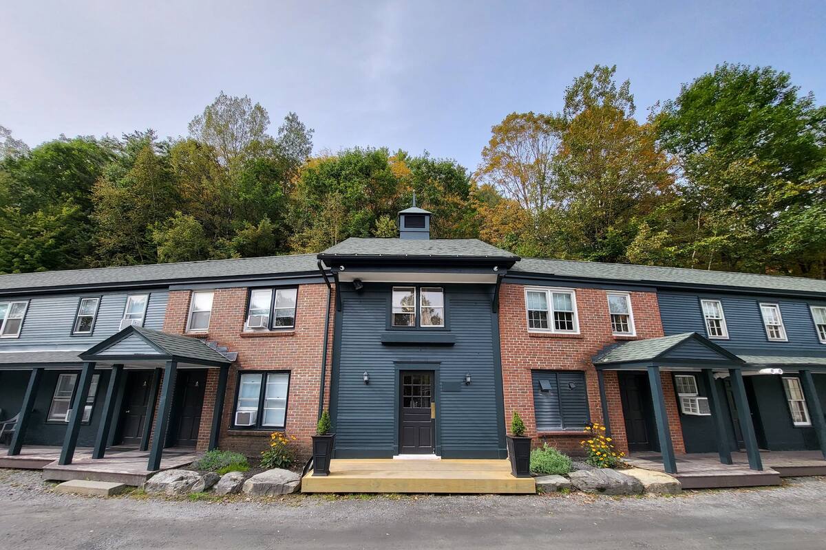 A two-story building with a central entrance, brick facade, and multiple windows.