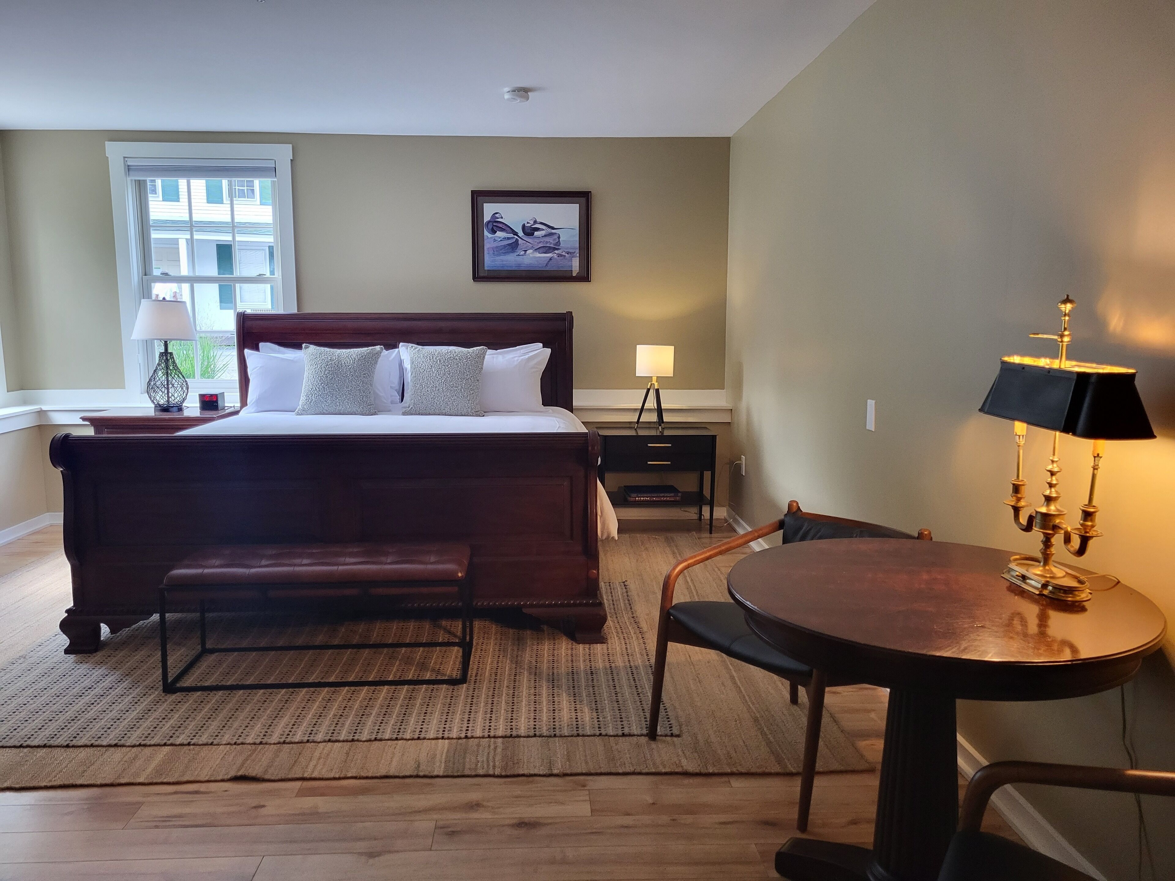 A bedroom with a large bed, bedside tables, a desk, and a chair.