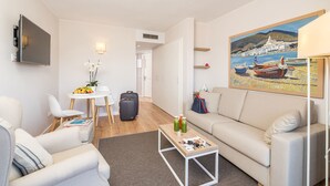 Un salon moderne comprenant un canapé, une table basse et un coin repas avec une table et des chaises.