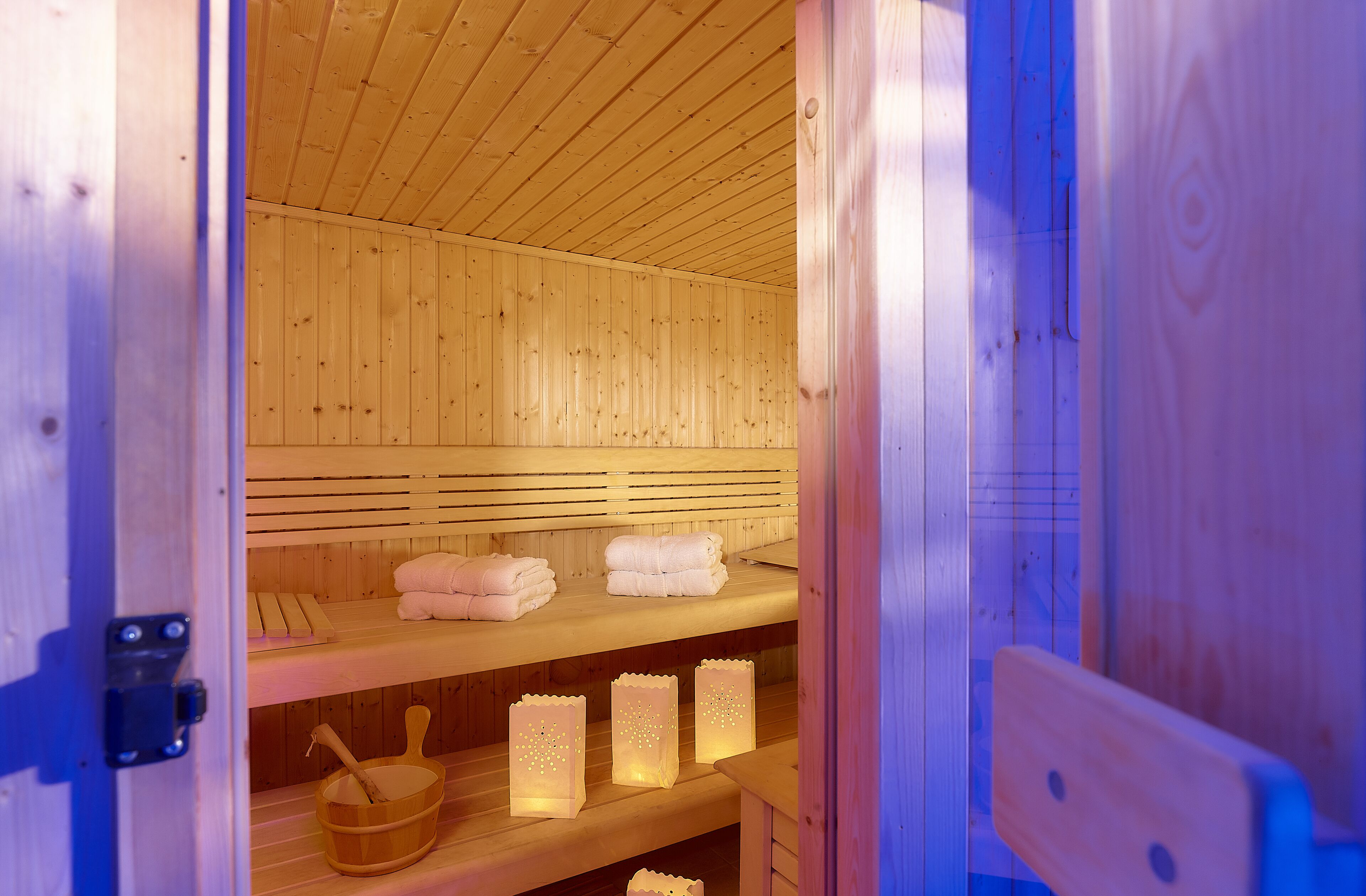 A wooden sauna with benches and towels.