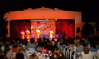 Un escenario con un telón rojo y la palabra "Furious" visible.