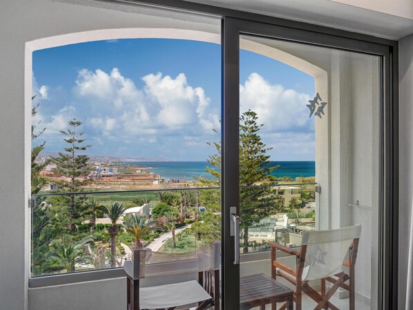 A balcony with a view of the sea and a cityscape.