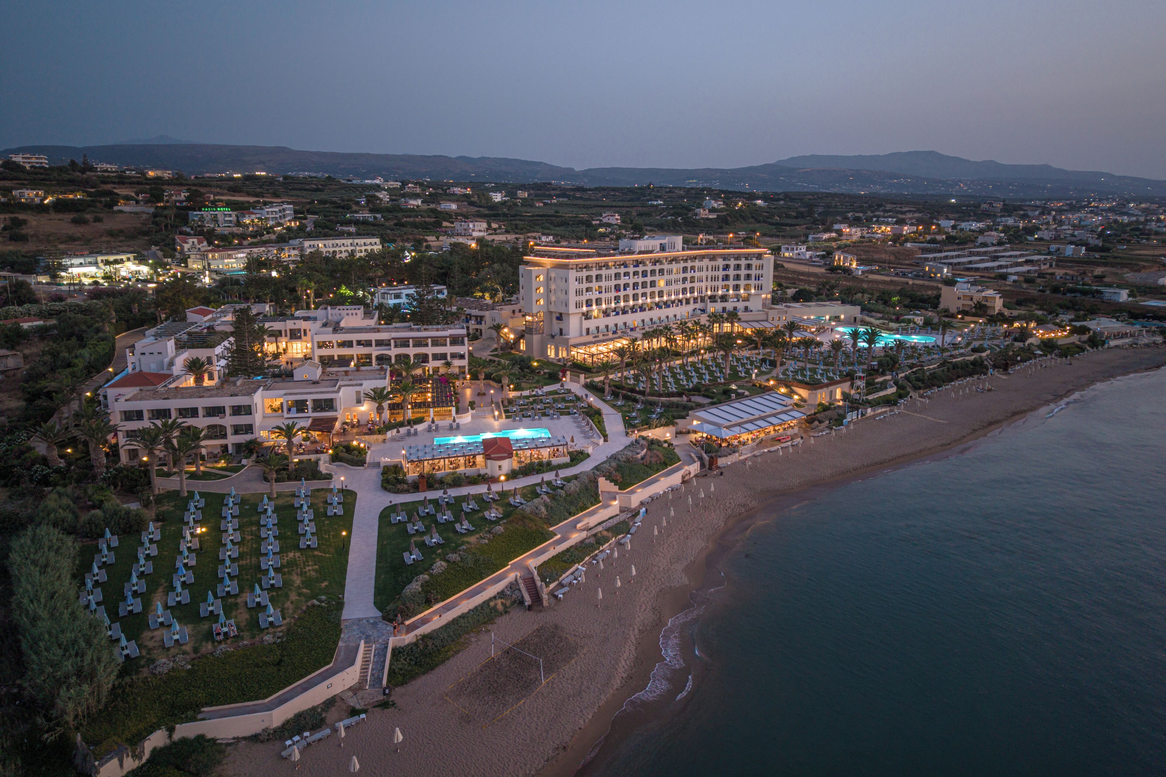 A resort with multiple buildings, a beach, and a pool area.