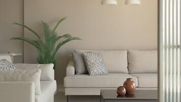 Una sala moderna con un sofá, un sillón y una mesa de centro con jarrones decorativos.
