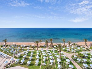 A resort with a beach view, rows of sun loungers, and palm trees. - Creta Star Hotel (Rethymno)