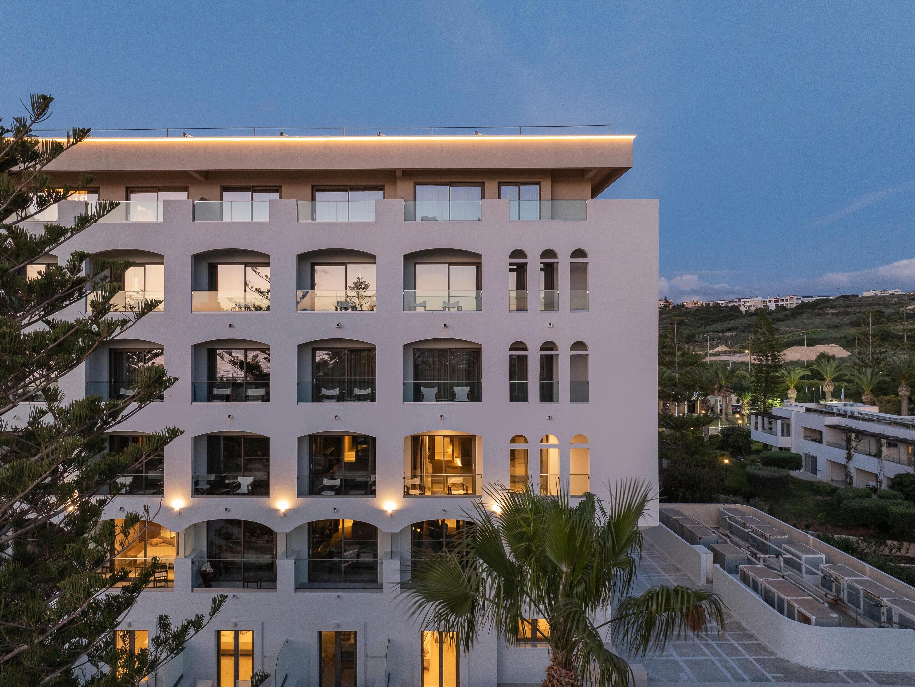 Un hôtel à plusieurs étages, doté d’un toit plat, de grandes fenêtres et d’un balcon.