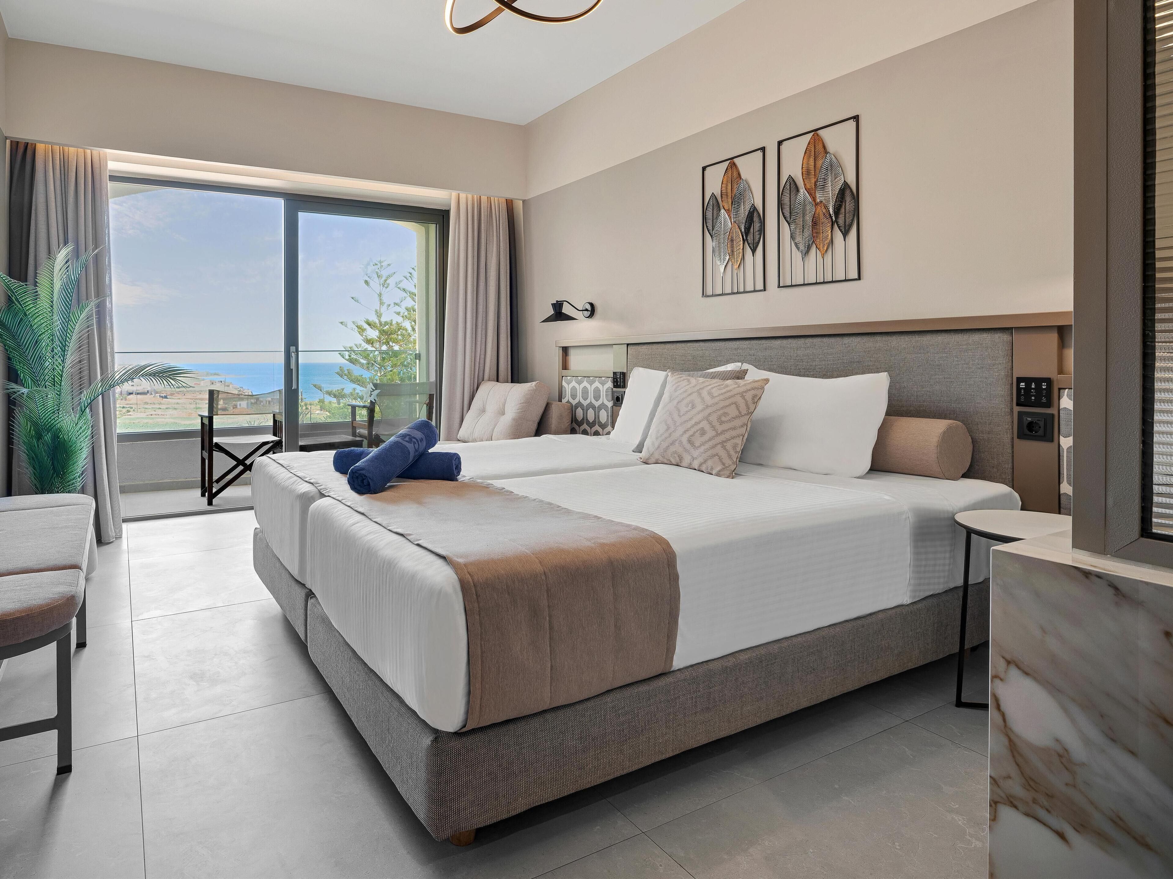 Ett modernt hotellrum med en stor säng, en balkong med utsikt och ett stort fönster.