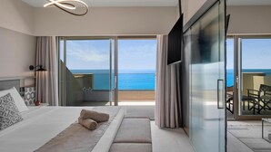 A modern hotel room with a large bed, a bench, a TV, and a balcony with a view of the sea. - Creta Star Hotel (Rethymno)