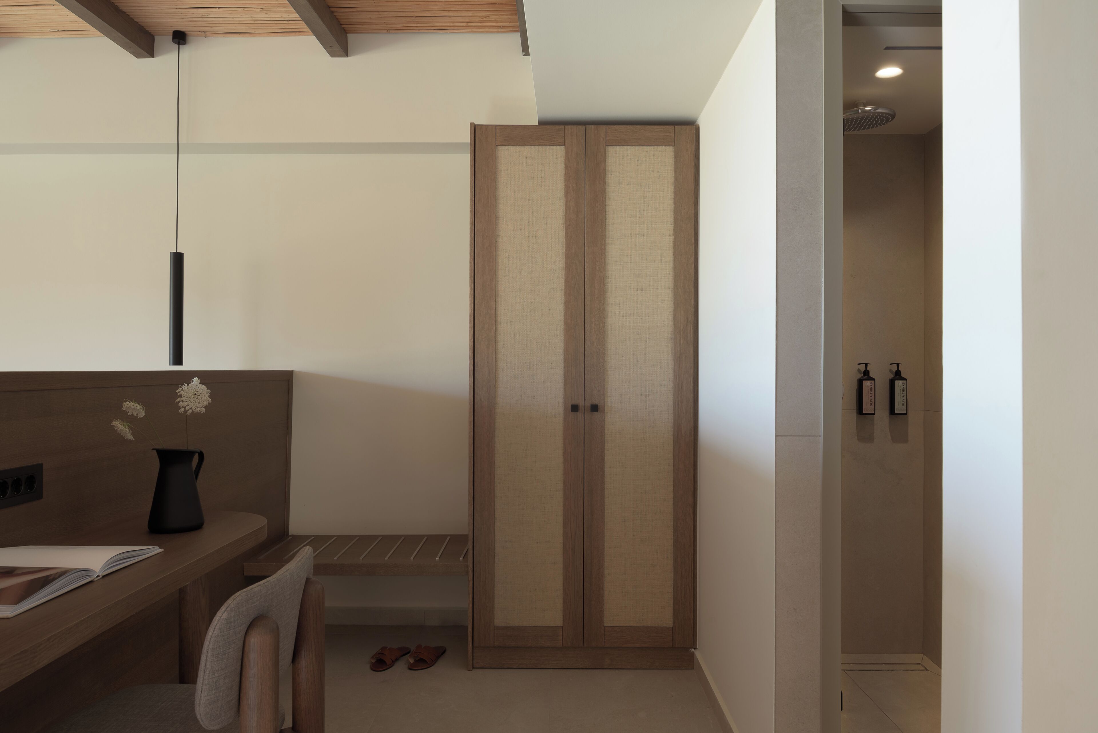 Een moderne badkamer met een douche, een houten wastafelmeubel en een handdoekrek.