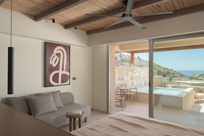 Quarto moderno com sofá, mesa e vista para a piscina e paisagem.