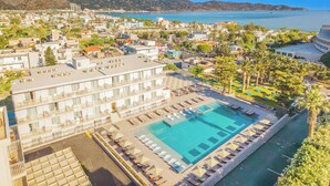 Ein Hotel mit großem Pool, mehreren Balkonen und Meerblick.
