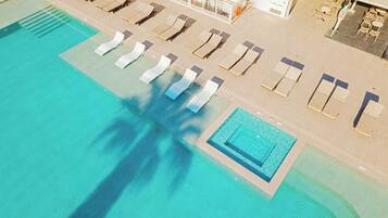An aerial view of a swimming pool with sun loungers and a separate section for diving.