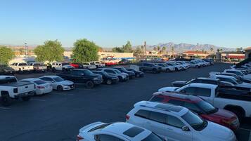 A parking lot with various vehicles, including cars and trucks, and a mountainous landscape in the background.