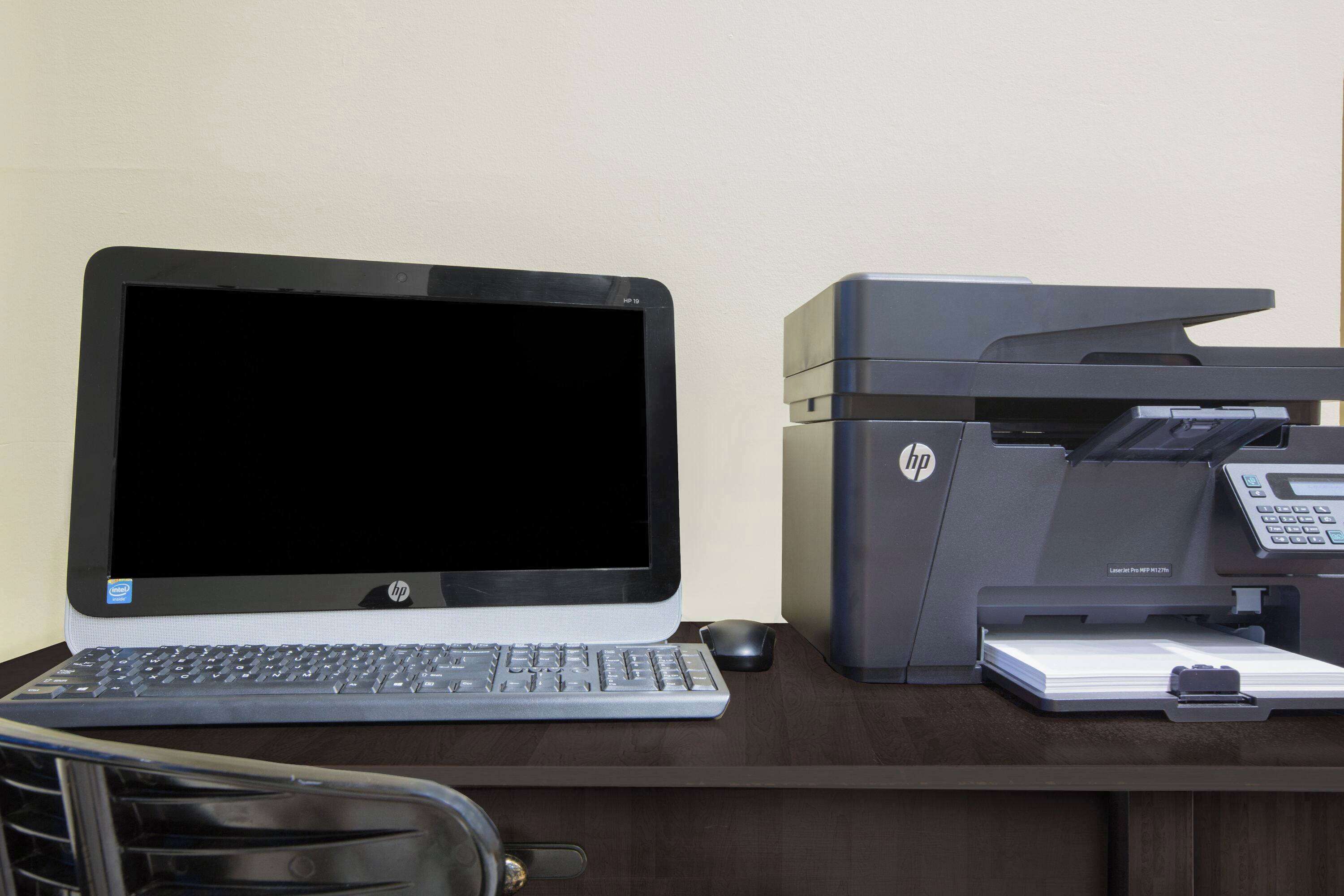 A laptop and an HP printer on a desk.