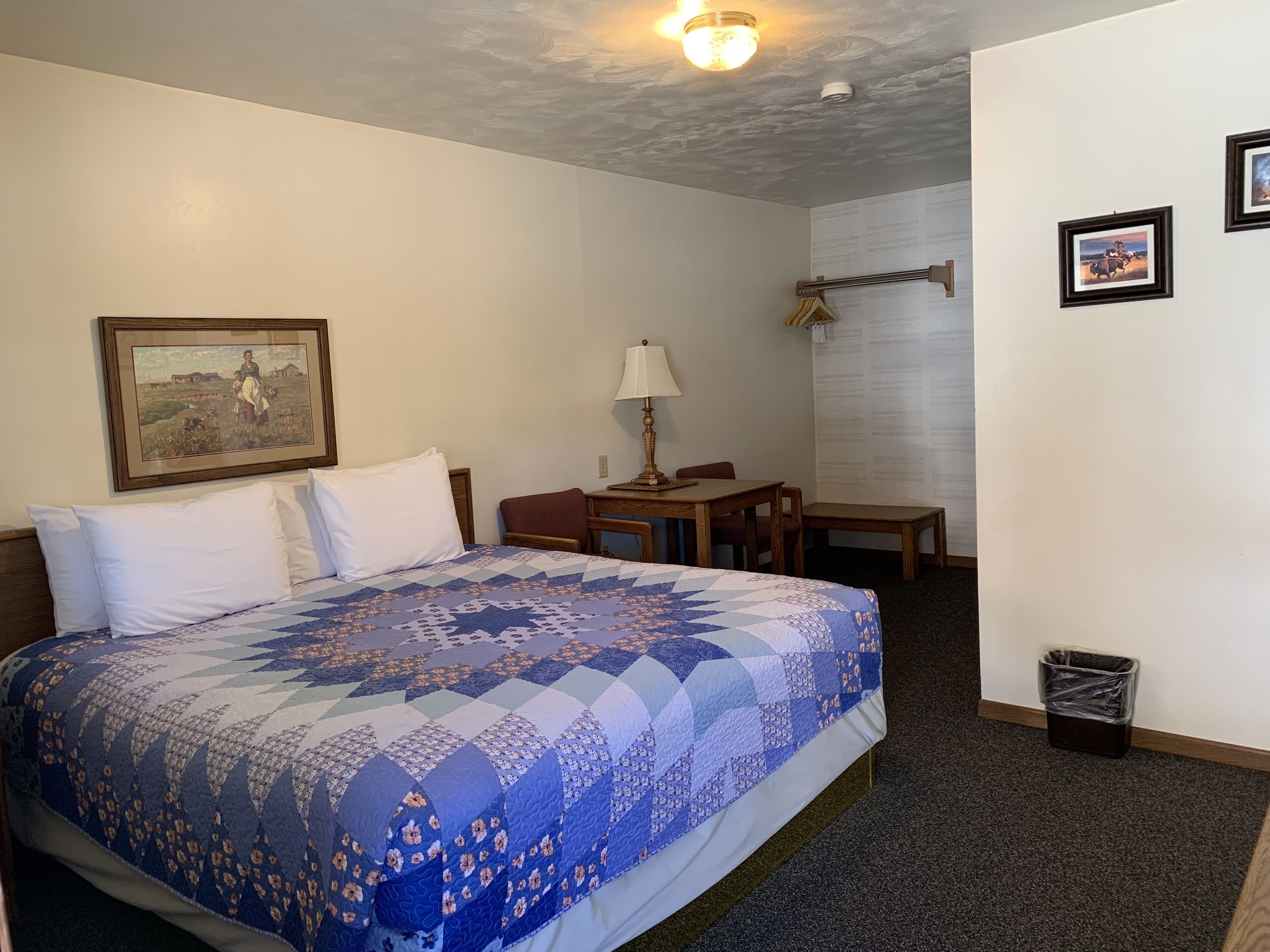 Una habitación de hotel con una cama grande, un escritorio, una silla y una mesita.