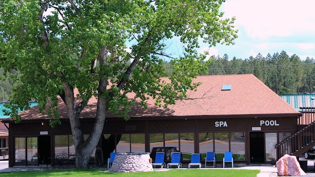 A building labeled SPA POOL with a covered seating area and a stone feature in front. - Chief Motel (Custer)