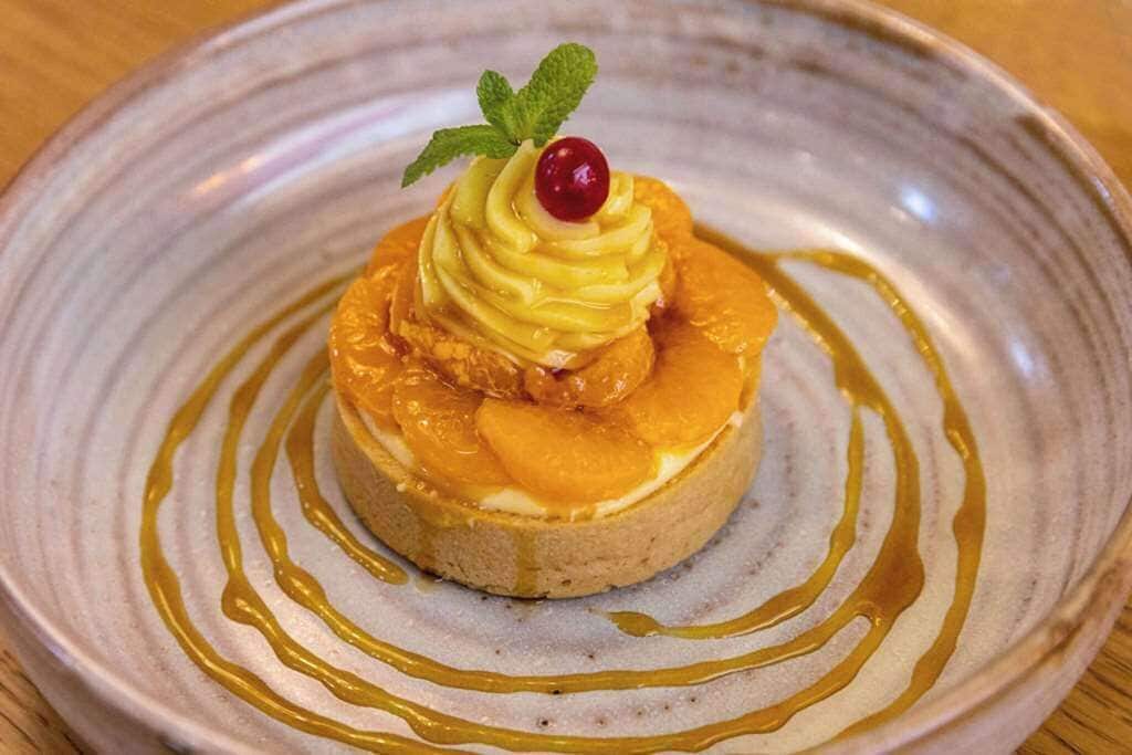 Un dessert servi dans une assiette, agrémenté d’une garniture.