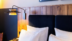 A hotel room with a bed, a nightstand, a lamp, and two framed pictures on the wall. - Four Points by Sheraton Paris Charles de Gaulle Airport (Roissy-en-France)