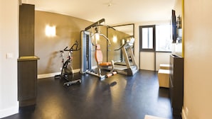 A gym with exercise equipment, a treadmill, and a mirror. - Four Points by Sheraton Paris Charles de Gaulle Airport (Roissy-en-France)