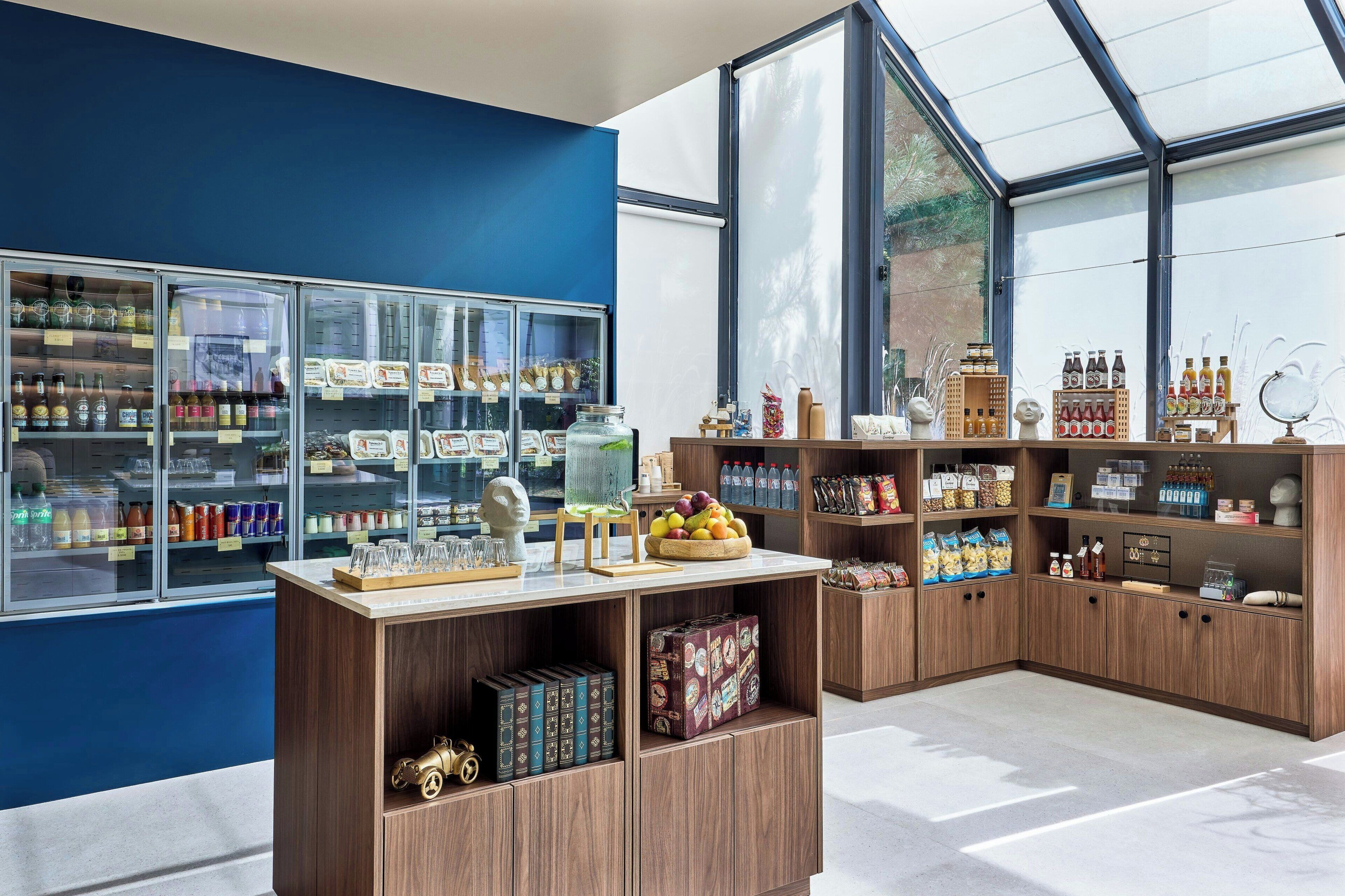 A modern retail space with glass display cases, wooden shelves, and a variety of products including beverages and snacks.