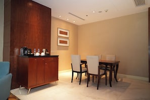 A dining area with a wooden cabinet, a table, and chairs. - New Coast Hotel Manila (Manila)