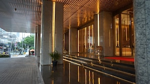 A modern hotel lobby with a polished floor, large columns, and a red carpet leading to the entrance. - New Coast Hotel Manila (Manila)