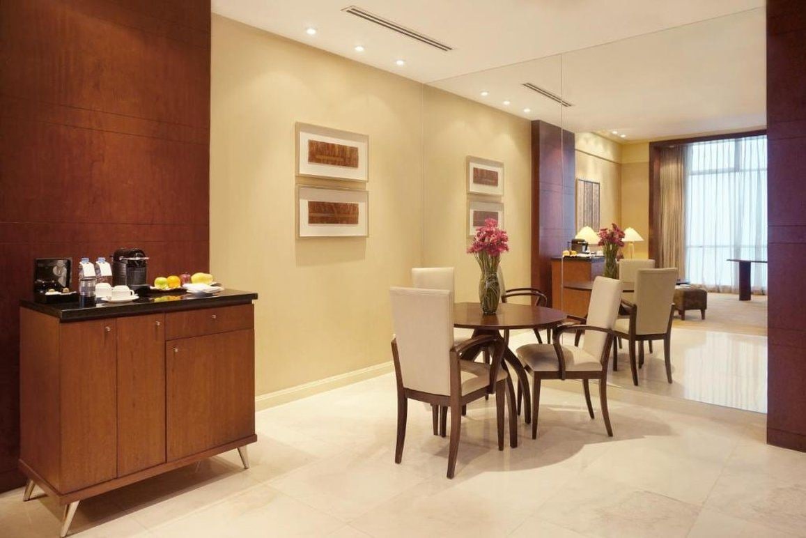 A modern dining area with a wooden cabinet, a round table, and chairs.