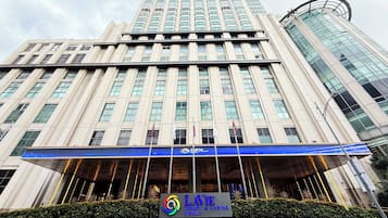 Un immeuble à plusieurs étages doté d’une entrée imposante, avec un auvent bleu et une enseigne indiquant « LAVIE Resort & Casino Manila ».