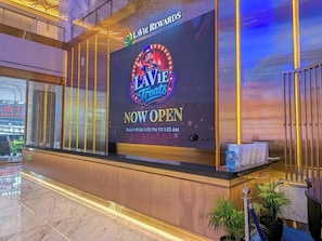 Una reception con un grande cartello che indica l'apertura di 'LAVIE TREATS'.