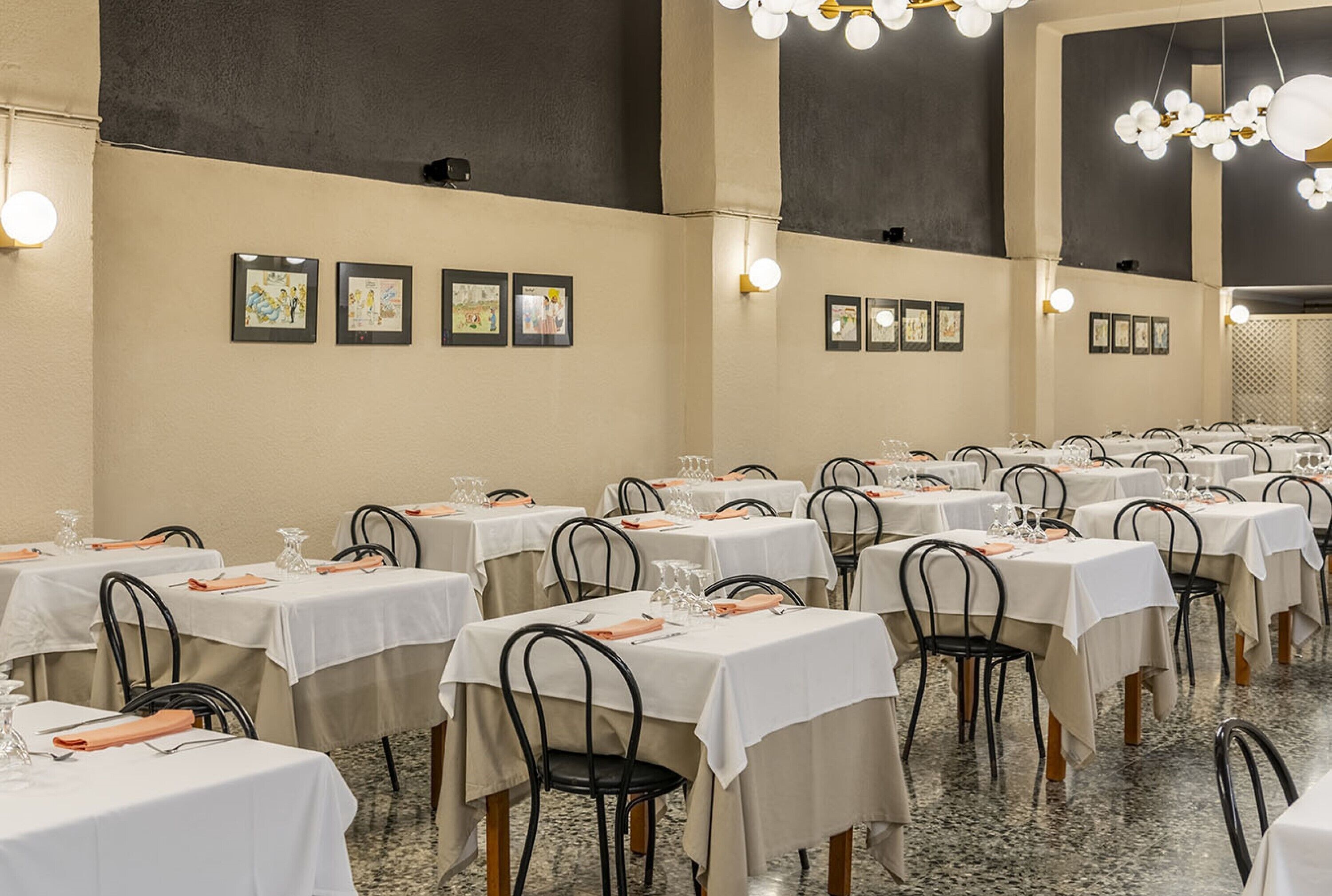 A banquet hall with multiple tables set for dining, each with white tablecloths and black chairs.