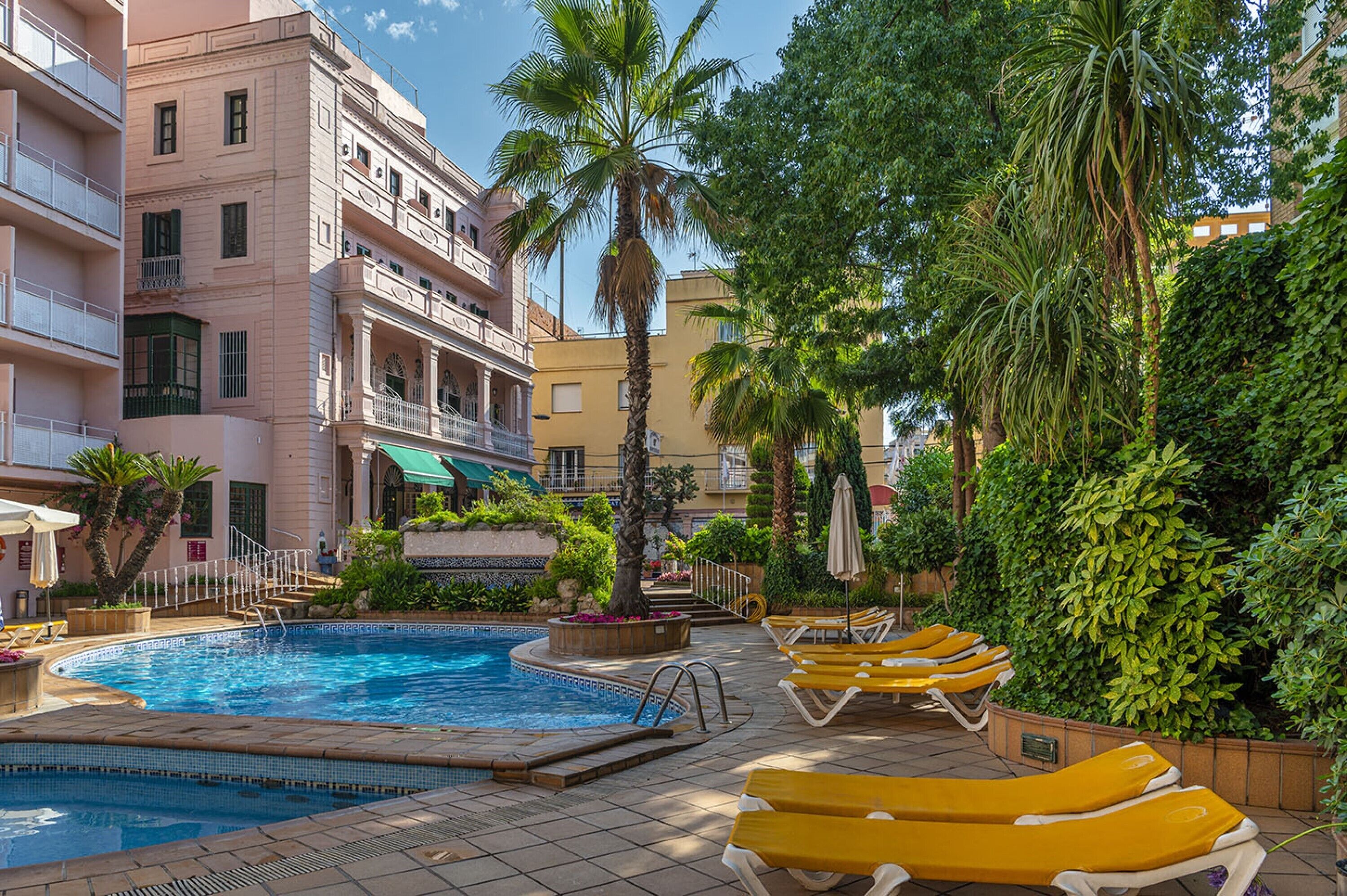 Una piscina al aire libre, sillones reclinables de piscina