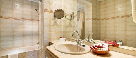 Baño con lavamanos, espejo y ducha.