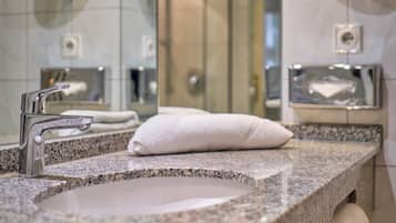 Ein Badezimmer mit einer Granit-Arbeitsplatte, einem Waschbecken, einem Spiegel und einem Handtuchhalter.