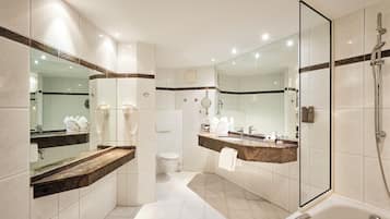 A modern bathroom with a glass-enclosed shower, a vanity with a marble countertop, and a large mirror.