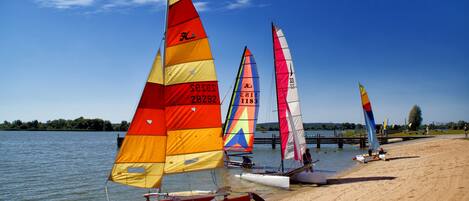 A beach with several sailboats anchored near the shore.