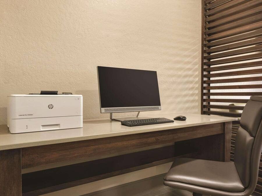 A desk with an HP printer, a monitor, and a keyboard.